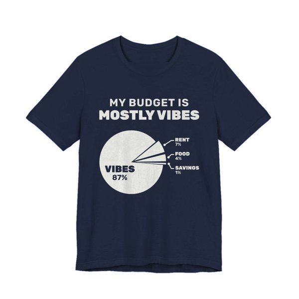 Navy t-shirt printed in off-white ink with “My Budget Is Mostly Vibes” above a pie chart: vibes 87%, rent 7%, food 4%, savings 1%