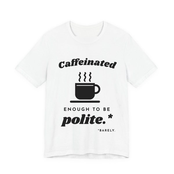 White t-shirt printed in dark ink with “Caffeinated” over a steaming coffee cup, then “Enough to Be polite.*” with a tiny footnote: “*Barely.”