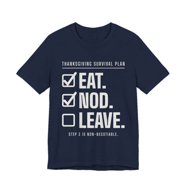 Navy t-shirt printed in off-white ink with a “Thanksgiving Survival Plan” checklist: Eat. (checked), Nod. (checked), Leave. (not yet), with “Step 3 is non-negotiable”