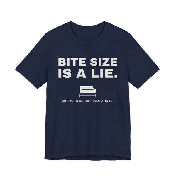 Navy t-shirt printed in off-white ink with “Bite Size Is a Lie.” above a tiny candy bar labeled “Actual size. Not even a bite.”