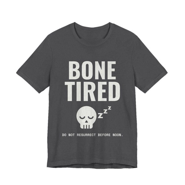 Dark Grey Heather t-shirt printed in off-white ink with “Bone Tired” above a sleeping skull with little z's, and “Do not resurrect before noon.”