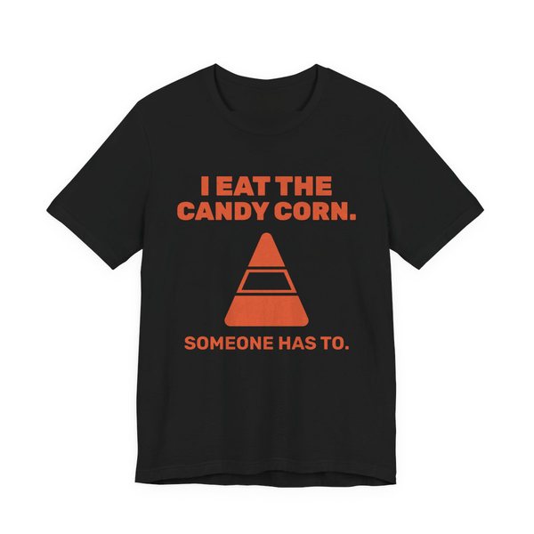 Black t-shirt printed in orange ink with “I Eat the Candy Corn.” above a big candy corn, with “Someone has to.”
