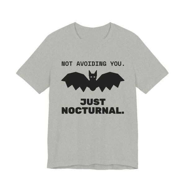 Athletic Heather t-shirt printed in dark ink with “Not Avoiding You.” above a bat with wings spread, then “Just Nocturnal.”