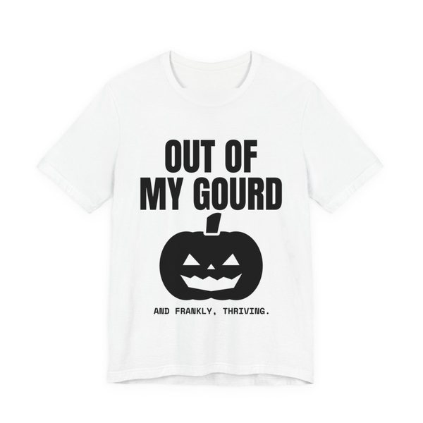 White t-shirt printed in dark ink with “Out of My Gourd” above a grinning jack-o'-lantern, with “And frankly, thriving.”