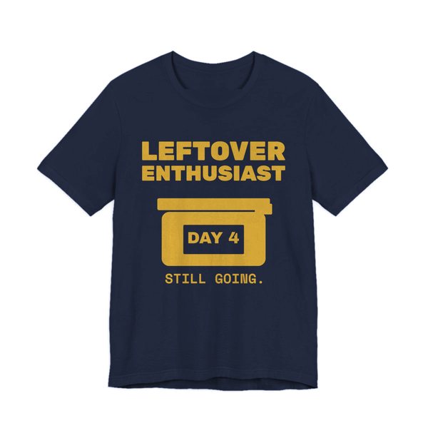 Navy t-shirt printed in gold ink with a takeout-style leftovers container and the words “Leftover Enthusiast”