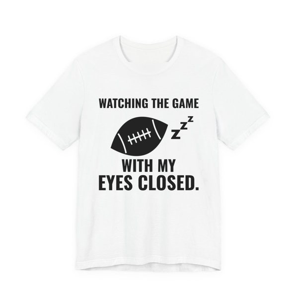White t-shirt printed in dark ink with the words “Watching the Game With My Eyes Closed.”